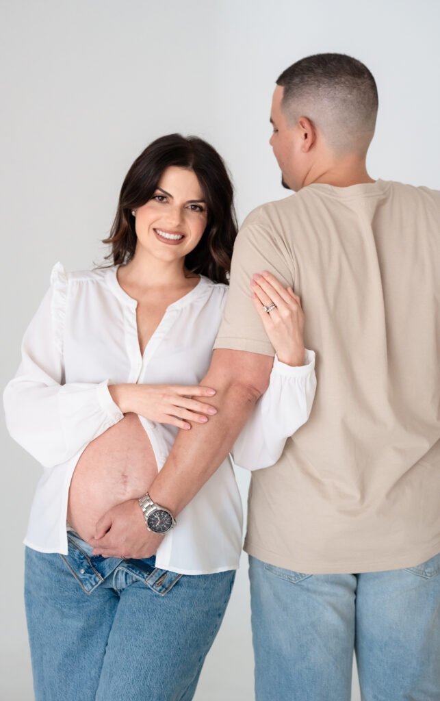 Dad holding baby bump during indoor studio maternity session.