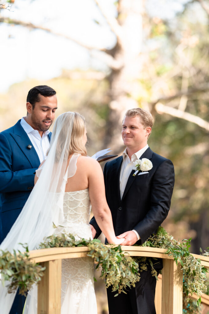charlottesville-backyard-wedding-couple-holding-hands-on-bridge