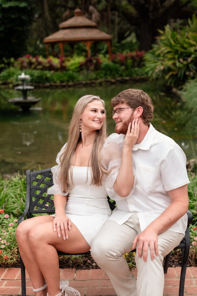 Engagement photo of Kristen and Brandon in front of wooden gazebo.