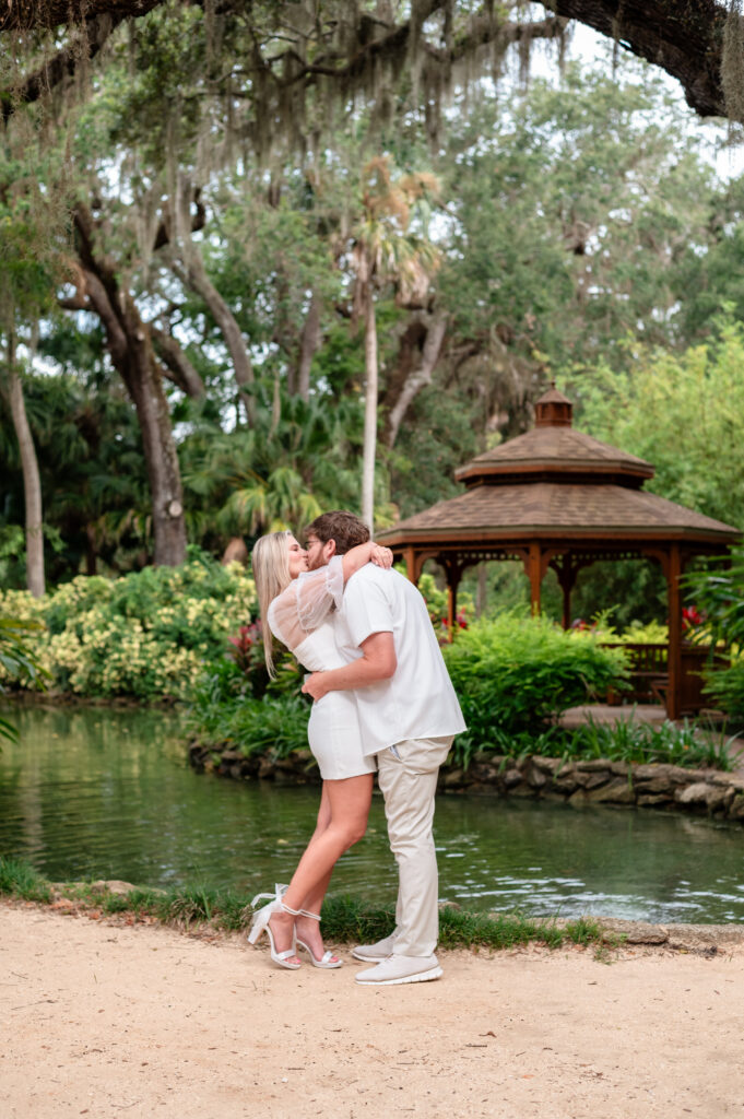 Engagement photo of Kristen and Brandon in front of wooden gazebo.