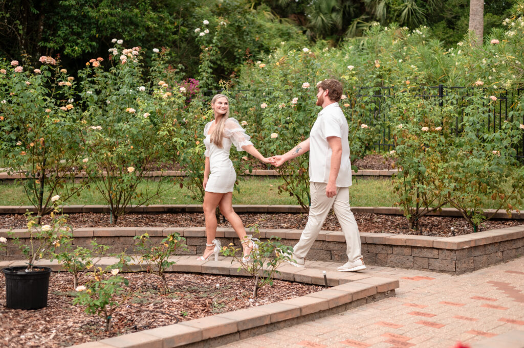 Kristen and Brandon walking through flower-lined path.