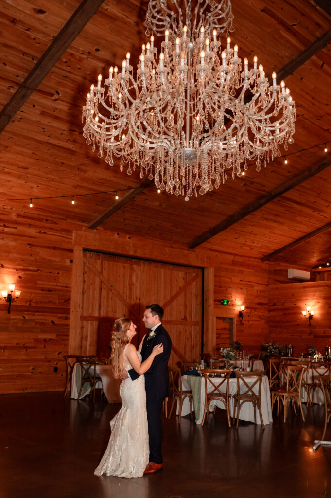First dance photo of bride and groom in romantic reception lighting