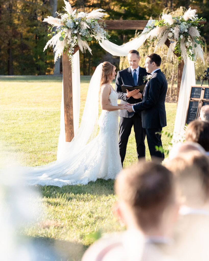 Bride and groom holding hands during their Cord of Three Strands ceremony tradition