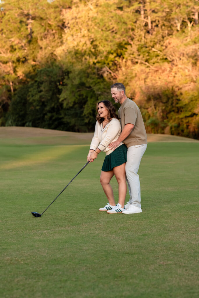 Mom and dad sharing a playful moment while lining up a putt at Deerwood Country Club
