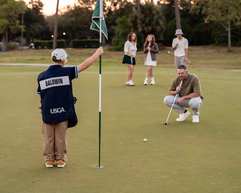 Baldwin family posing near golf cart during country club photo session in Jacksonville