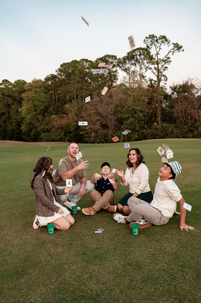 Family gathered around deck of cards on the golf course in Jacksonville