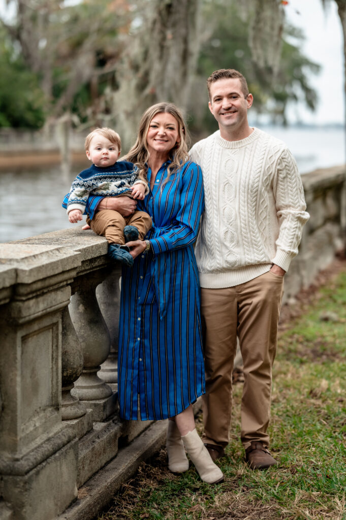 Family portrait at Yacht Basin Park Jacksonville with parents and toddler near the waterfront railing