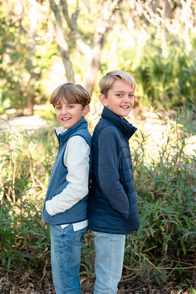 Children’s portrait of two brothers standing beneath moss covered oak trees at Yacht Basin Park