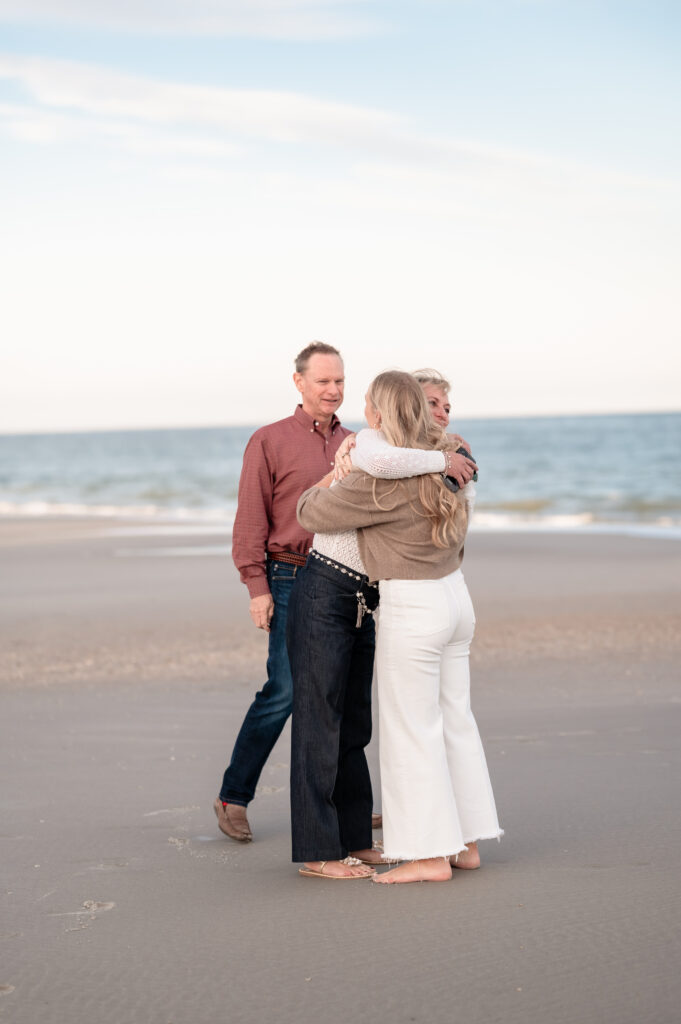 Rachel embracing her parents on the beach after getting engaged in Jacksonville.