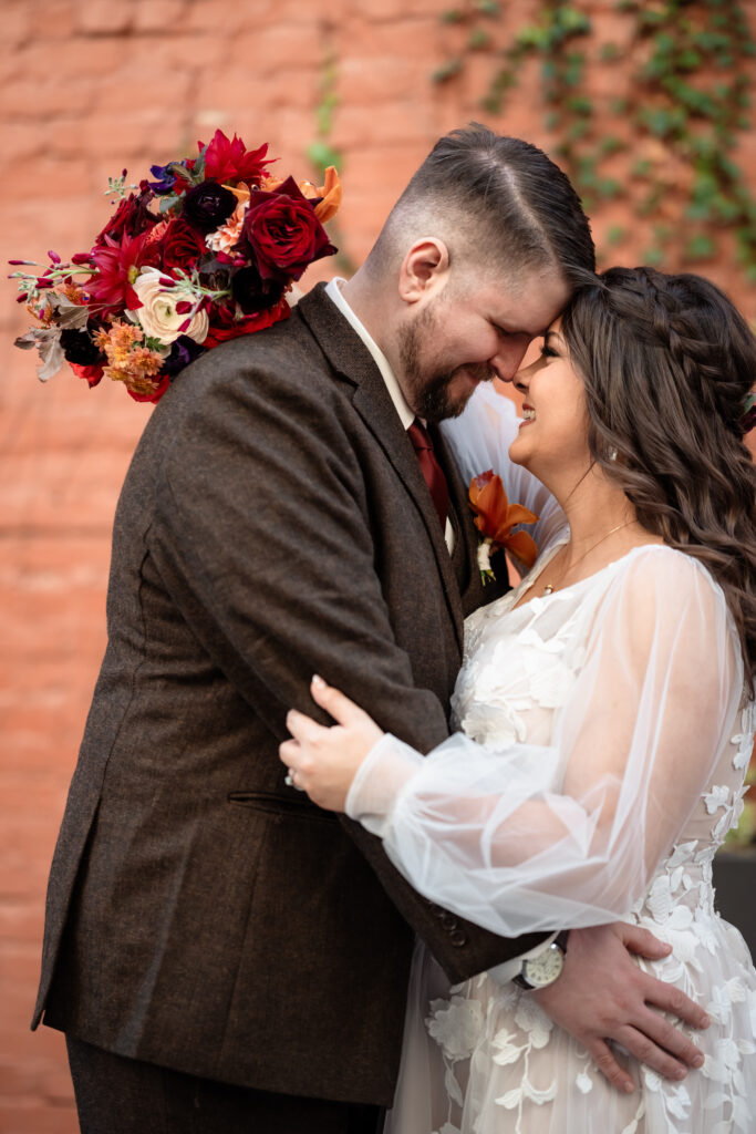 Bride laughing with her arm around the groom during relaxed rooftop portraits in Richmond Virginia.