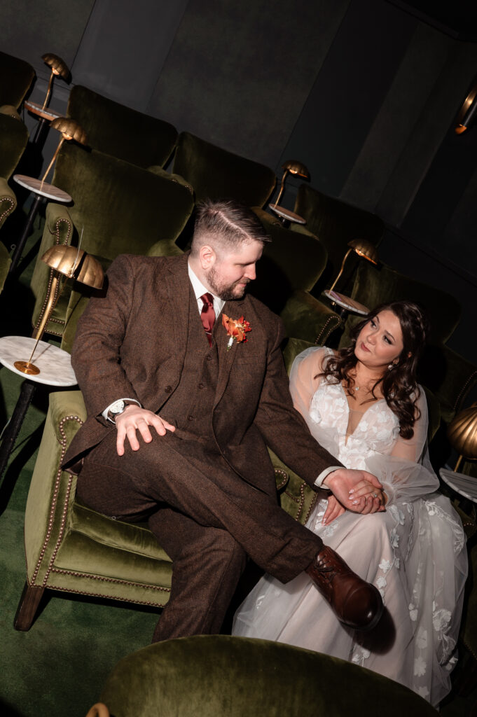 Romantic portrait of bride and groom sitting together in a cozy lounge space during their Richmond wedding.