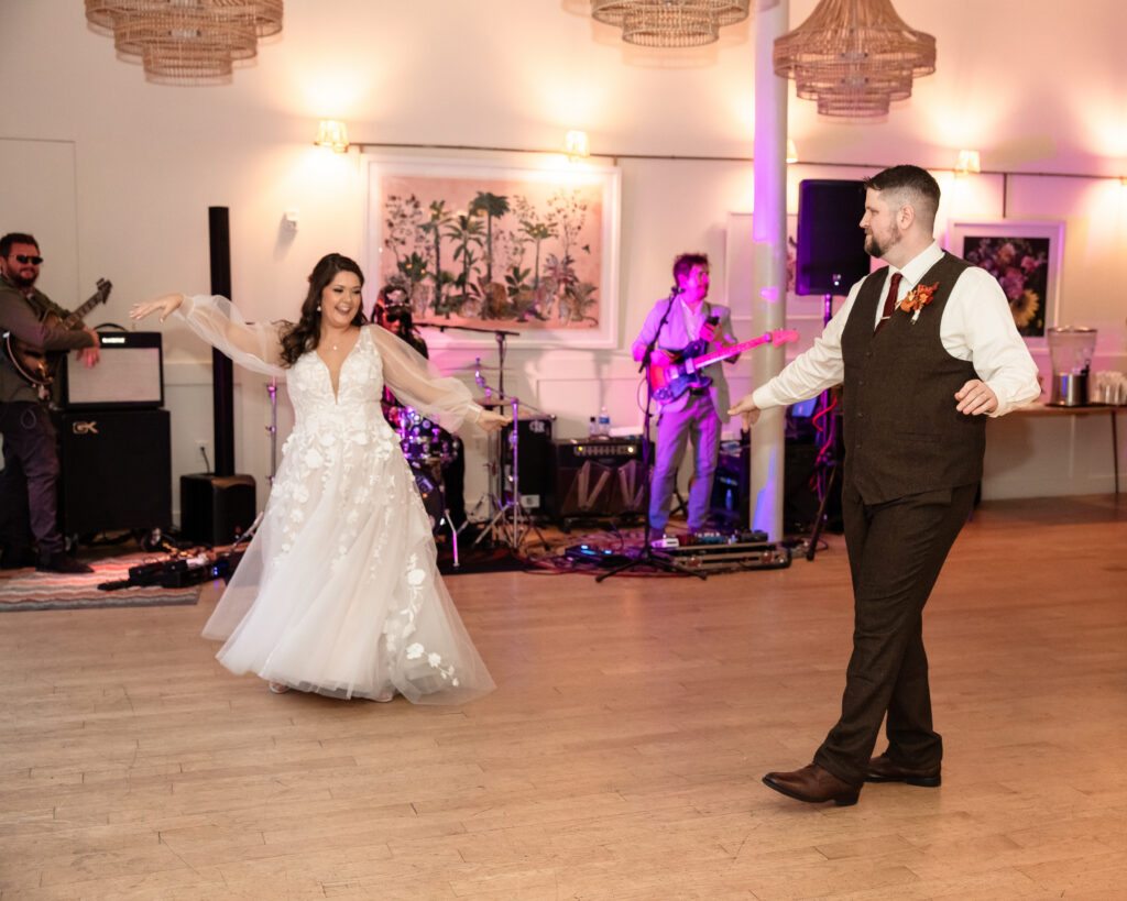 Bride and groom laughing together on the dance floor during their wedding celebration.