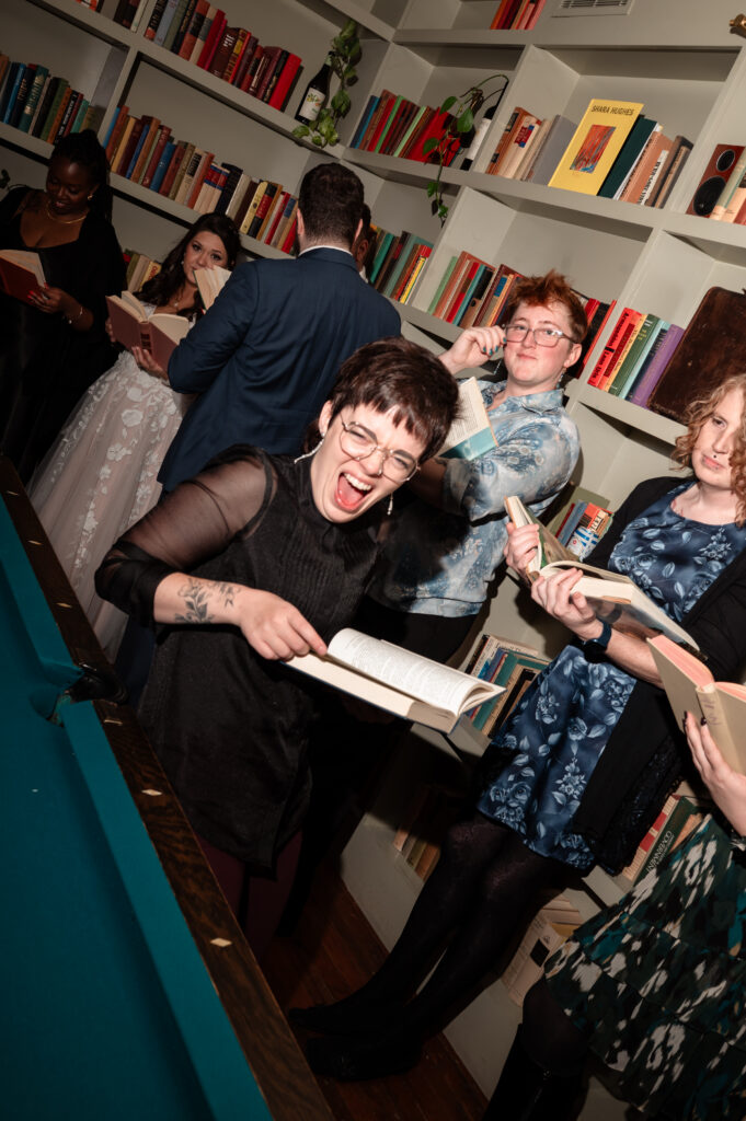 Guests gathering around a pool table during the wedding reception celebration.