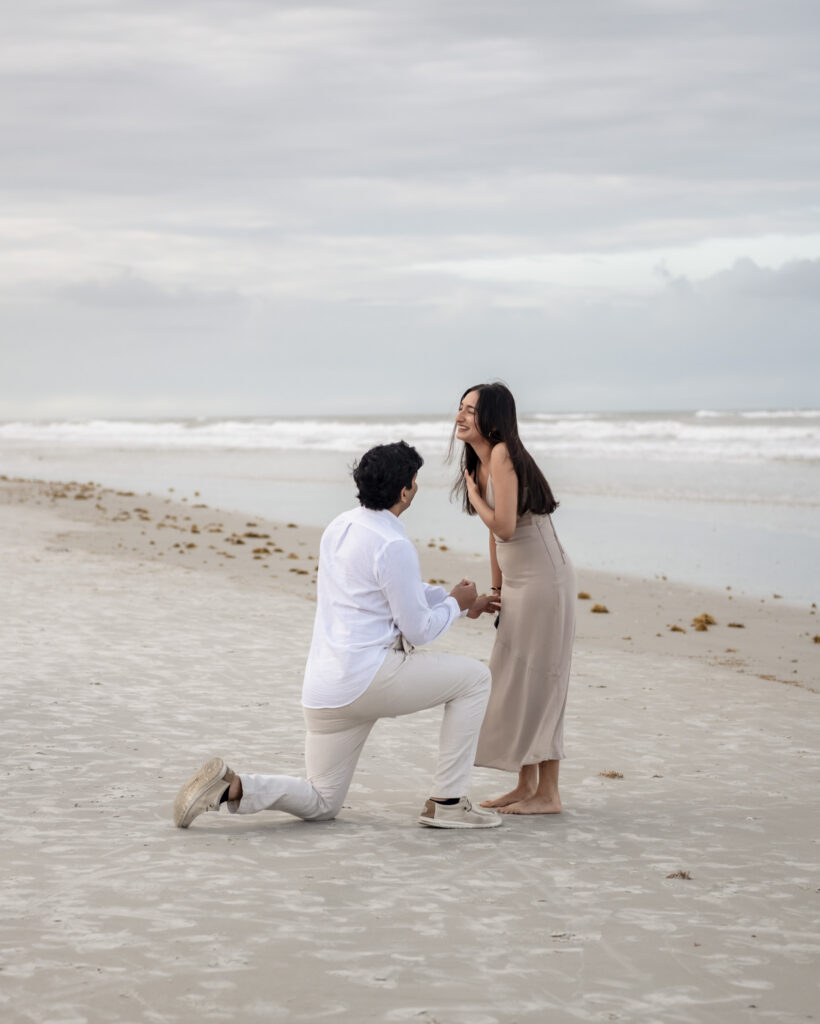 Couple embracing after a successful beach proposal.