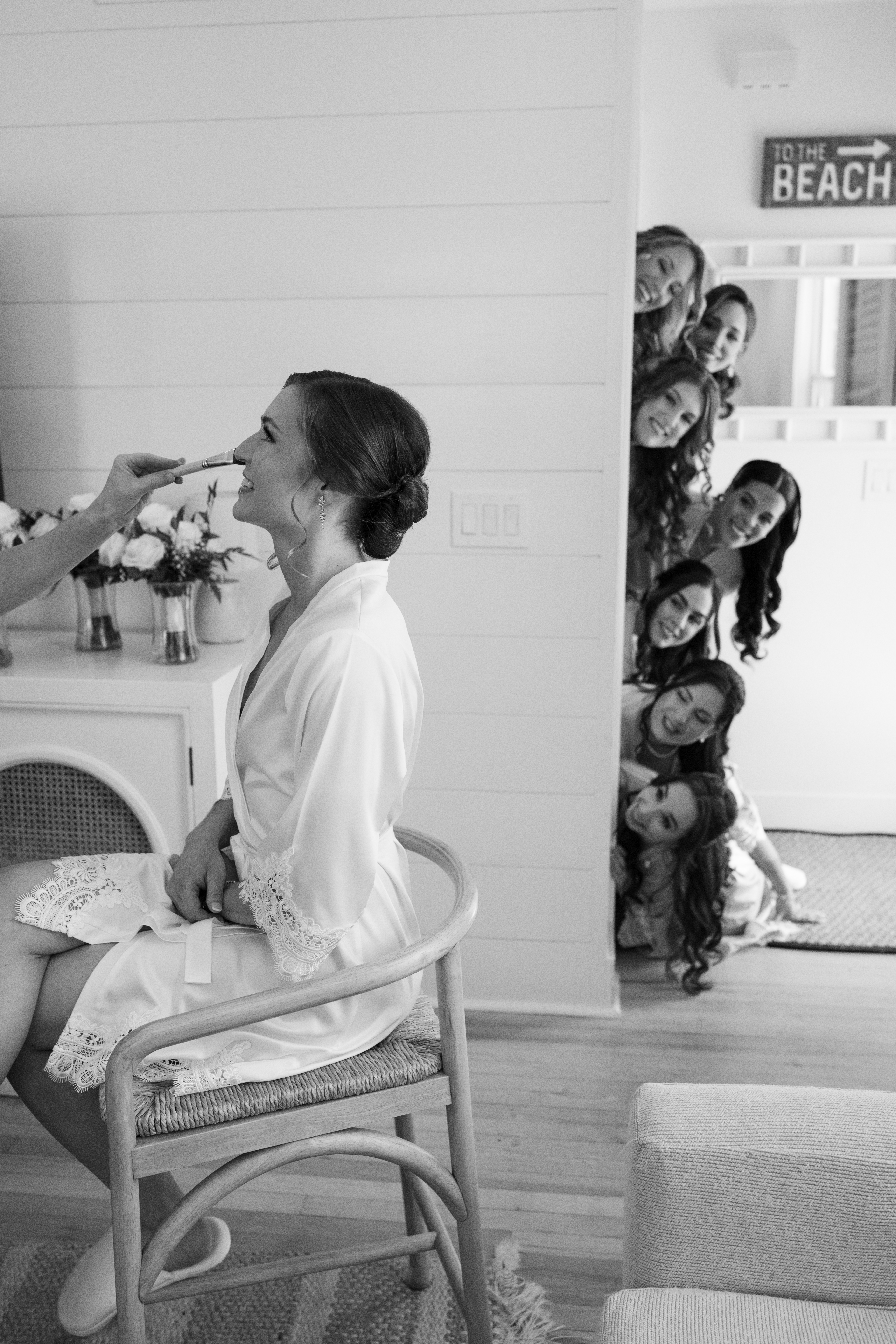 Bride laughing with her bridesmaids while getting ready.